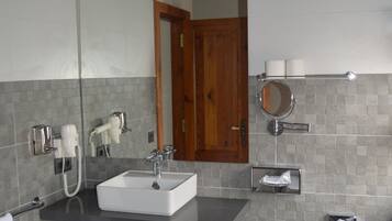A modern bathroom with a white sink, bidet, and a mirror.