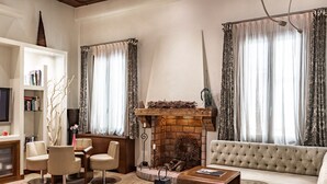 A living room with a fireplace, a sofa, a coffee table, and a bookshelf. - Abbazia De Luxe (Venice)