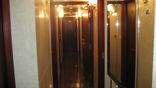 A hotel hallway with mirrored walls, a polished floor, and a series of doors. - 1ST Homestay - HK Taiwan Hostel (Kowloon)