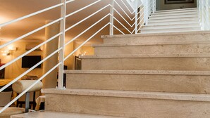 A staircase with a white railing leading to an upper floor. - Hotel Demar (Olbia)
