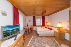 A cozy room with a bed, a desk, a television, and a lamp. - Appartement Kitzsteinhorn (Zell am See)