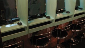 A row of computer stations with chairs in a public area. - Hong Kong Co-living Space, Kowloon Youth Village (Kowloon)