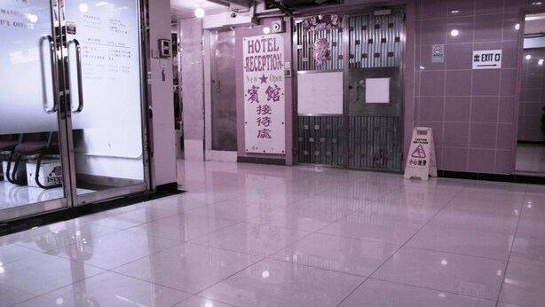 A hotel reception area with a sign indicating 'New Open' and a 'Hotel Reception' sign. - Hong Kong Co-living Space, Kowloon Youth Village (Kowloon)
