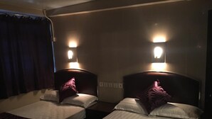 Two single beds with headboards, each with a wall-mounted light fixture and a decorative pillow. - Hong Kong Co-living Space, Kowloon Youth Village (Kowloon)