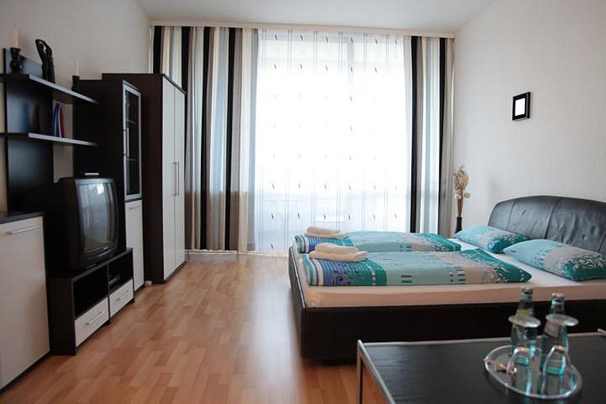 Un dormitorio con cama, televisor y armario.