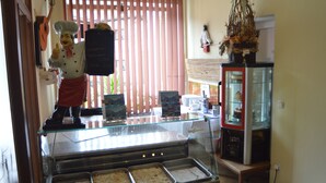 A buffet area with multiple food trays, a glass display case, and a decorative plant. - Hotel Gasthaus Café Bavaria (Inzell)