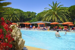 Una piscina al aire libre, sombrillas, tumbonas