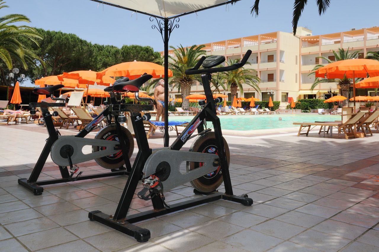 Un espacio exterior para ejercitarse con bicicletas estáticas y una piscina.