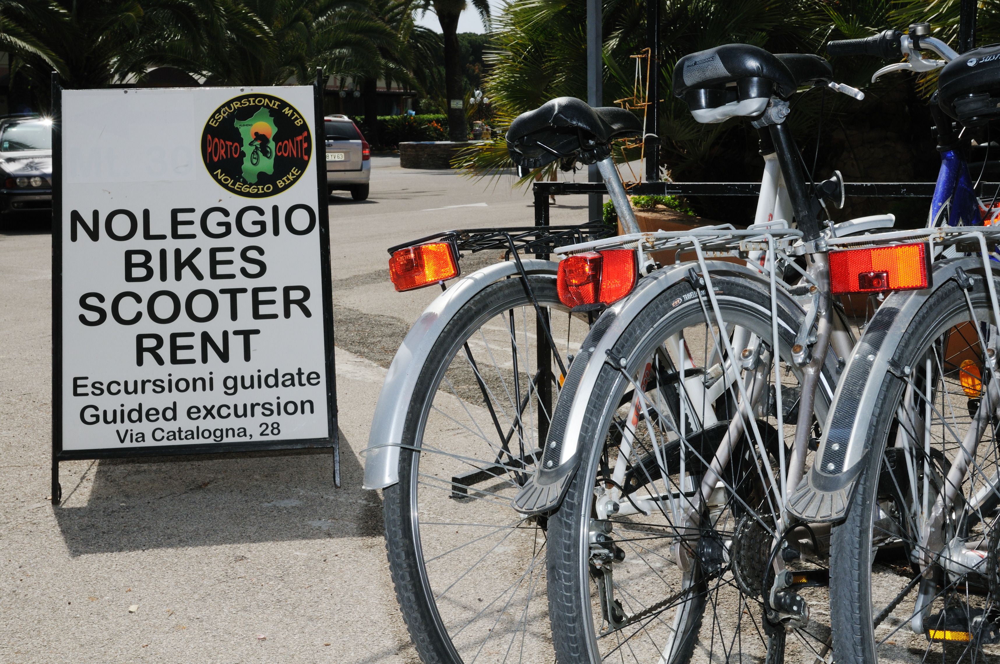 Señal de Noleggio Bikes & Scooter Rent, con una bicicleta estacionada cerca.