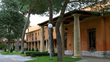 Stroll through a tranquil courtyard surrounded by traditional columns and beautifully maintained hedges.