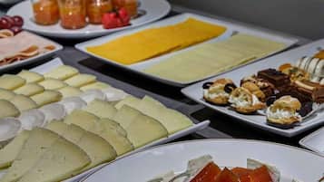 Ein reichhaltiges Buffet mit verschiedenen Käsesorten, Früchten und Gebäck.