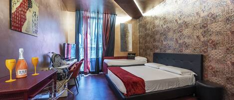 A hotel room with a bed, a desk with a chair, a TV, and a large window with curtains.