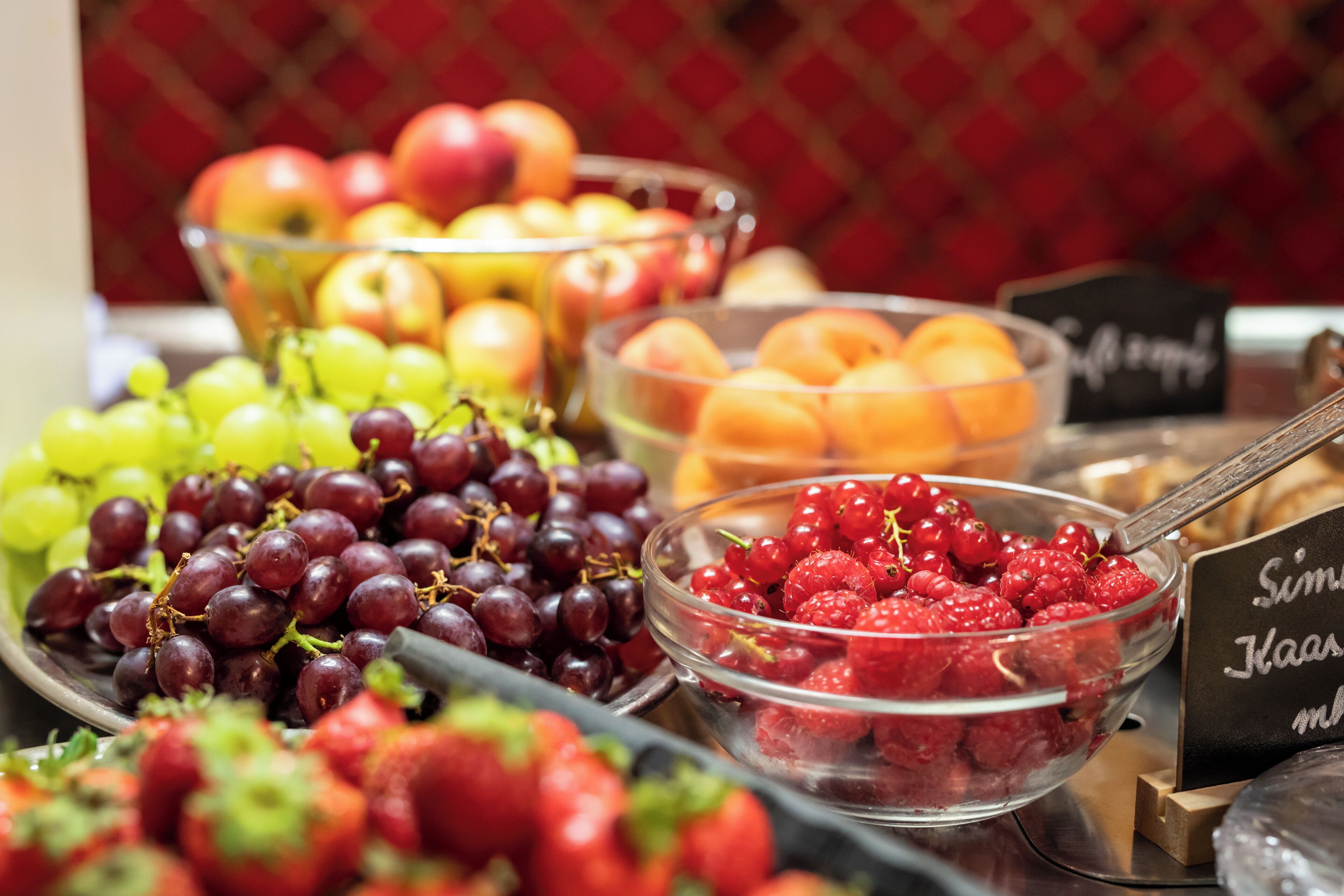Un buffet proposant une variété de fruits, notamment des raisins, des pommes et des baies.