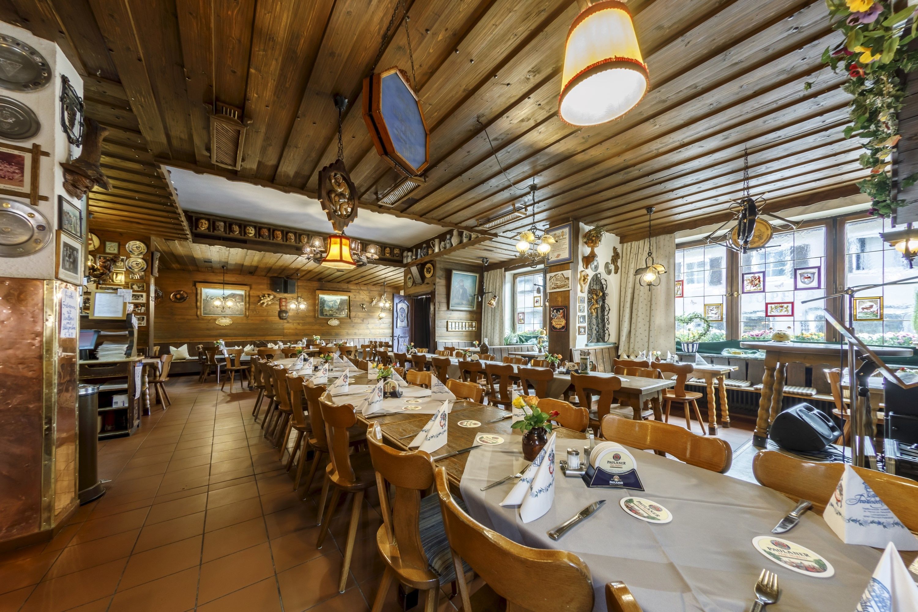 Un restaurant avec des plafonds en bois, de longues tables et des chaises.