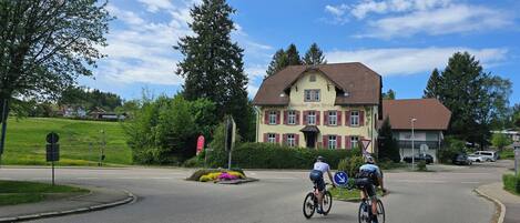 A building with a red-tiled roof and a sign that reads "Gasthof Zum Kreuz".
