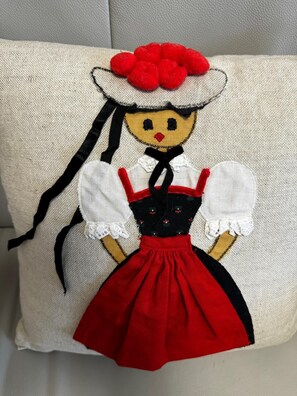 A pillow with a stitched figure of a person in traditional attire. - Hotel zum Kreuz St Peter (Sankt Peter)