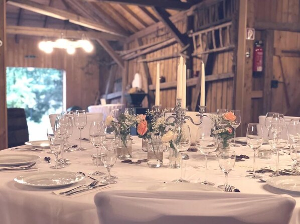 A table set for a formal event in a rustic wooden room with candle holders and floral centerpieces. - Hotel zum Kreuz St Peter (Sankt Peter)