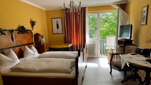 Une chambre d’hôtel avec un grand lit, un bureau, une chaise, une télévision et une vue sur l’extérieur.