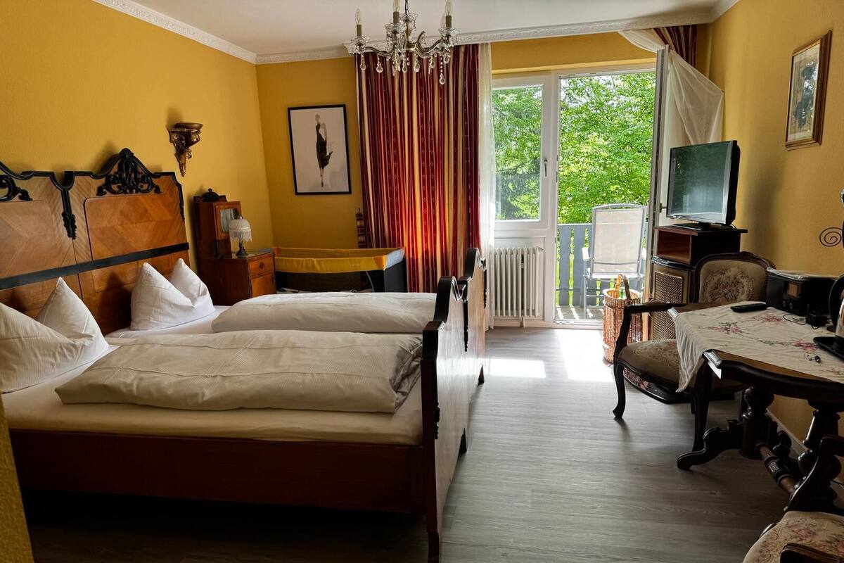 Een hotelkamer met een groot bed, een bureau, een stoel, een televisie en uitzicht op het omliggende landschap.
