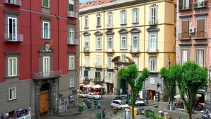 A street view with multi-story buildings, a sidewalk, and parked cars. - Domus Gemi (Naples)
