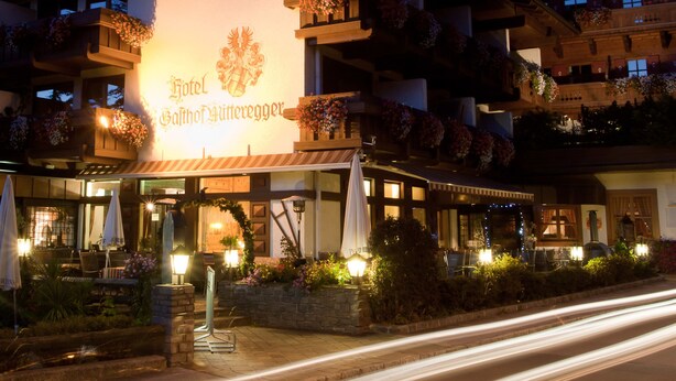 Un hotel con un letrero llamativo, terraza exterior y jardineras en los balcones.