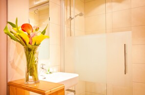 A bathroom with a white sink, a mirror, and a shower. - Hotel Gasthof Mitteregger (Kaprun)