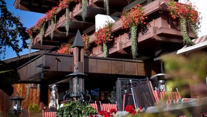 Un edificio de varios pisos con balcones decorados con flores rojas y follaje.