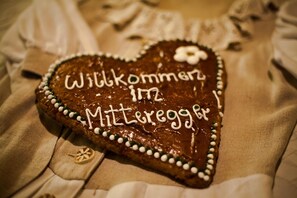 A heart-shaped gingerbread with "Willkommen 172" written on it, placed on a tablecloth. - Hotel Gasthof Mitteregger (Kaprun)