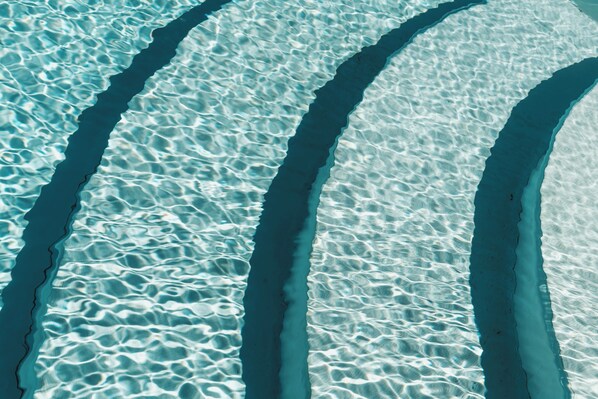 Una piscina al aire libre de temporada, sombrillas
