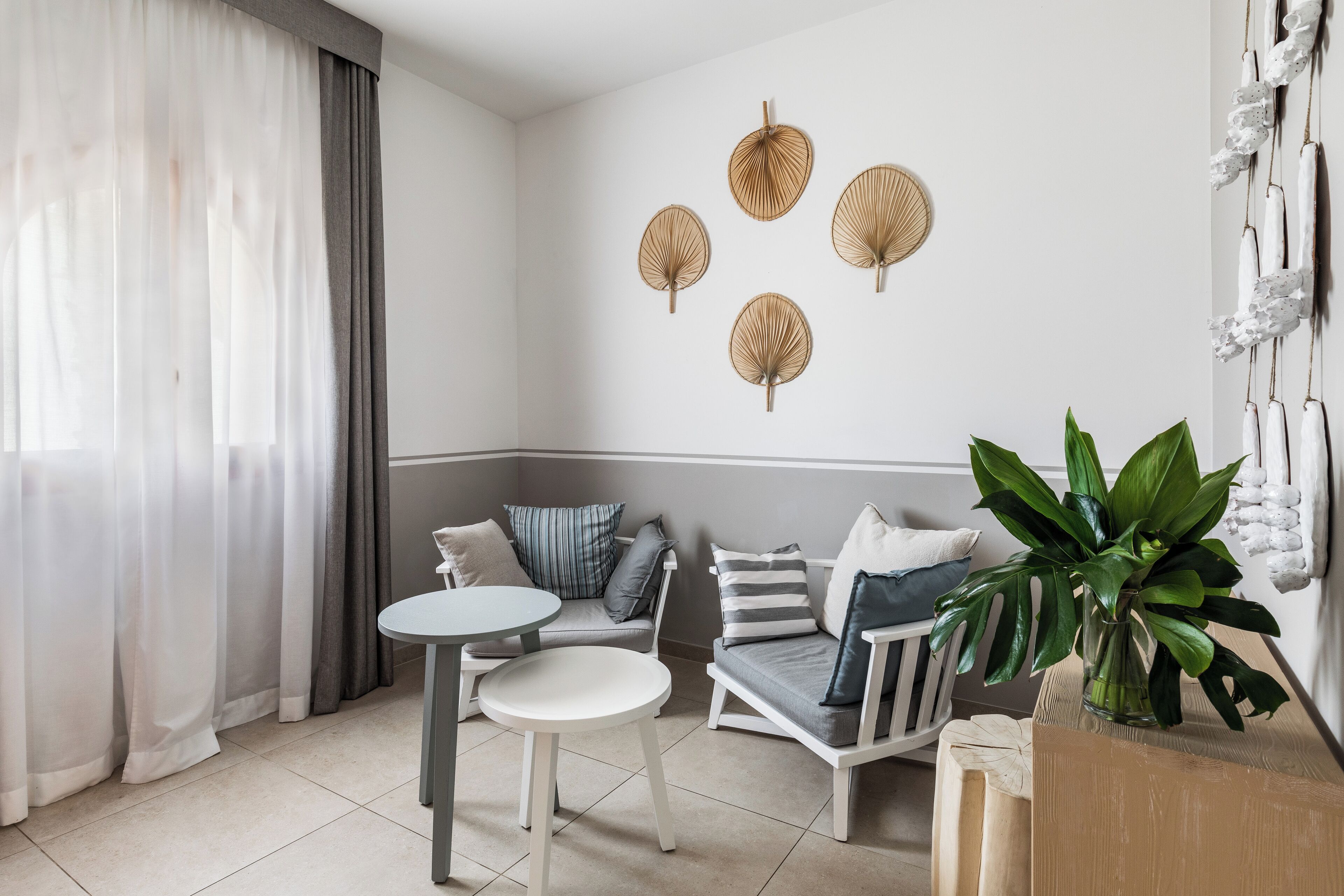 A modern living room with a sofa, a small round table, and a potted plant.