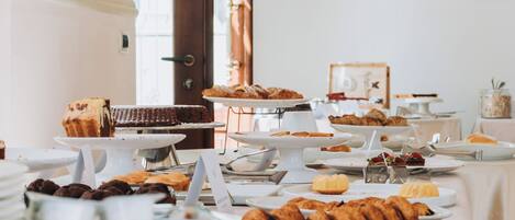 A buffet with various pastries and desserts on white serving stands.