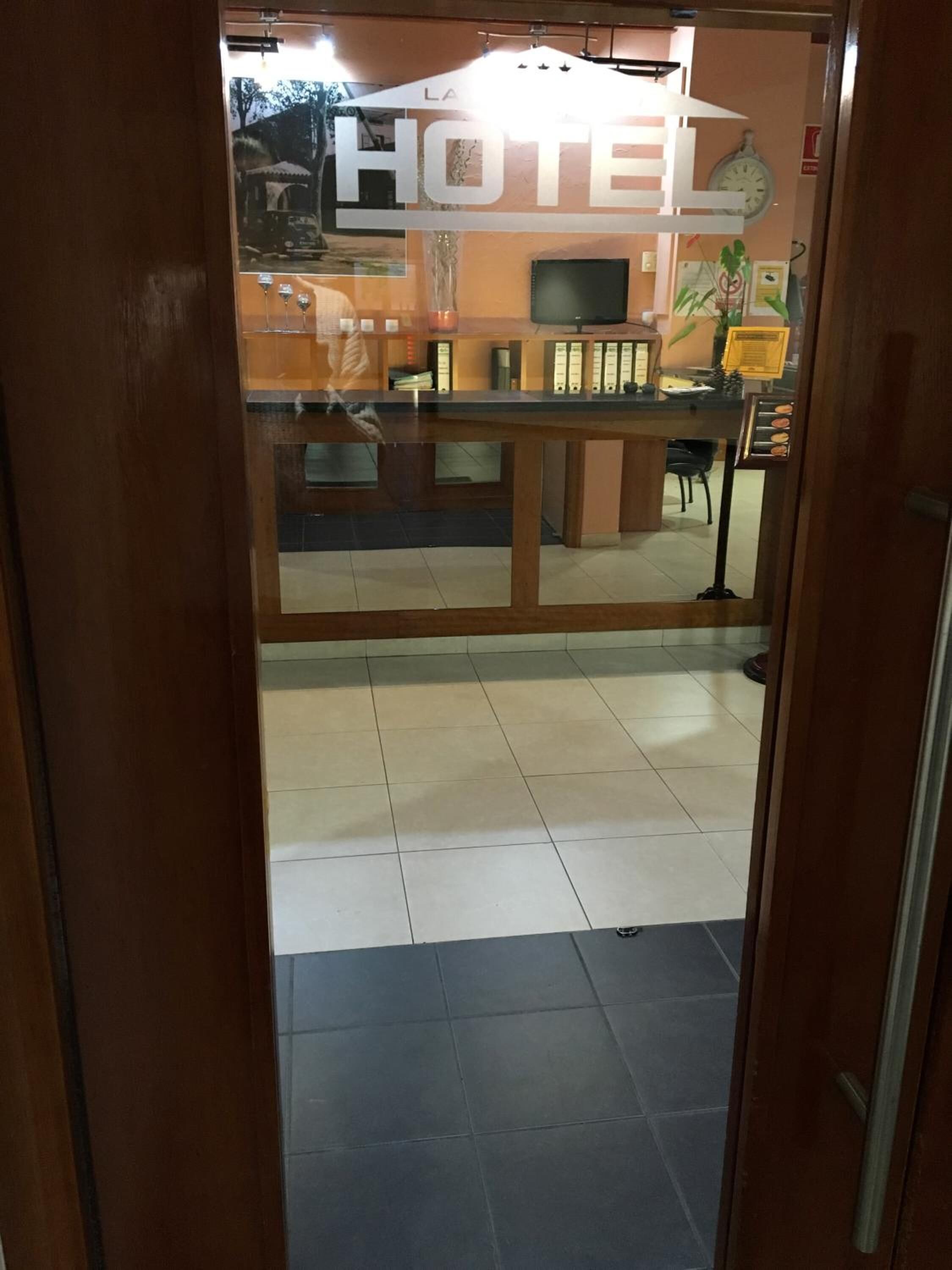 A hotel reception area with a reception desk, a clock, and a sign that reads "HOTEL".