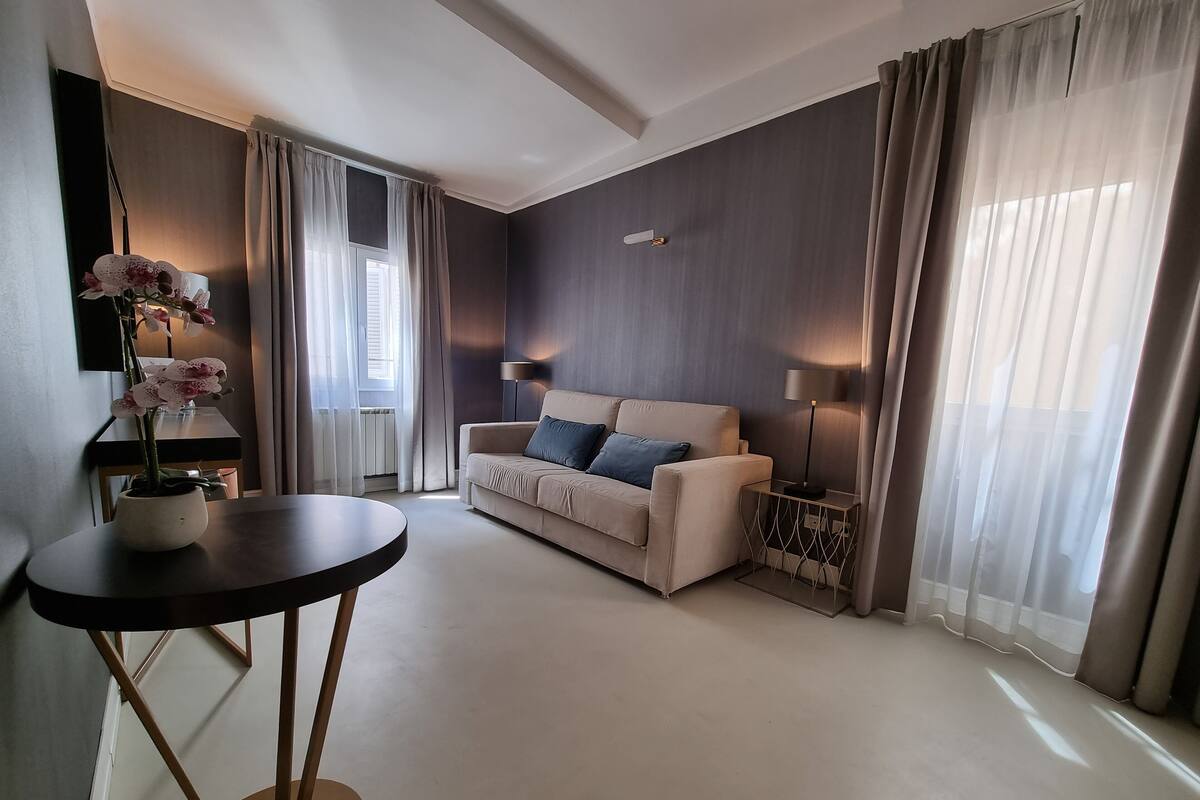 Een moderne woonkamer met een bank, een bijzettafeltje en een potorkidee.