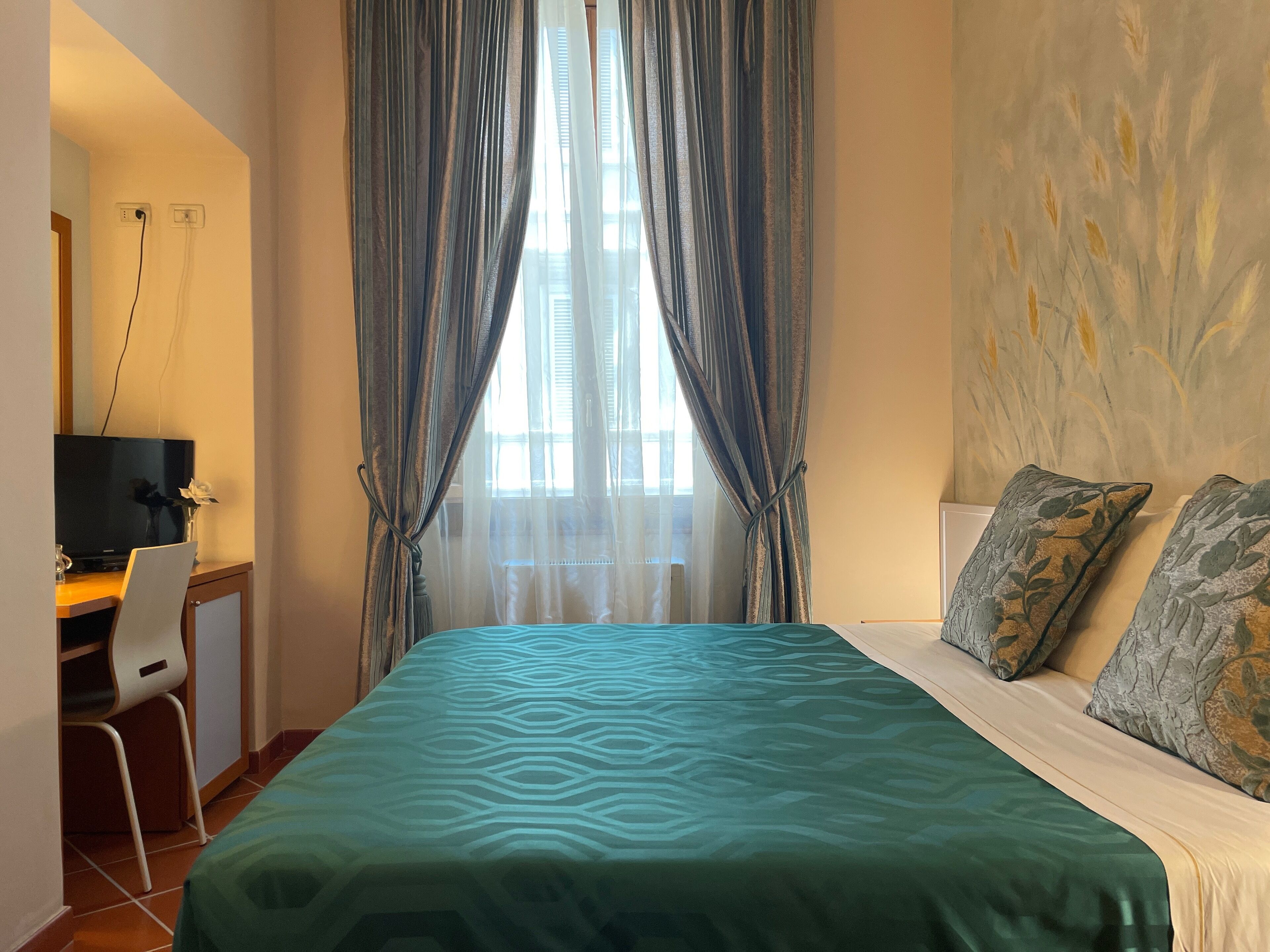 Une chambre à coucher avec un lit, un bureau, une chaise et un téléviseur.