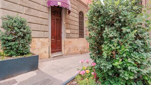 A building with a stone facade, a wooden door, and a purple awning.