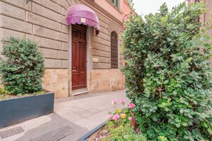 Un edificio con facciata in pietra, una porta in legno e un tendone viola.