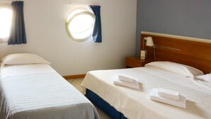 A hotel room with two single beds, a round window, a nightstand, and a lamp. - Albergo Meublè Abatjour (Mantua)