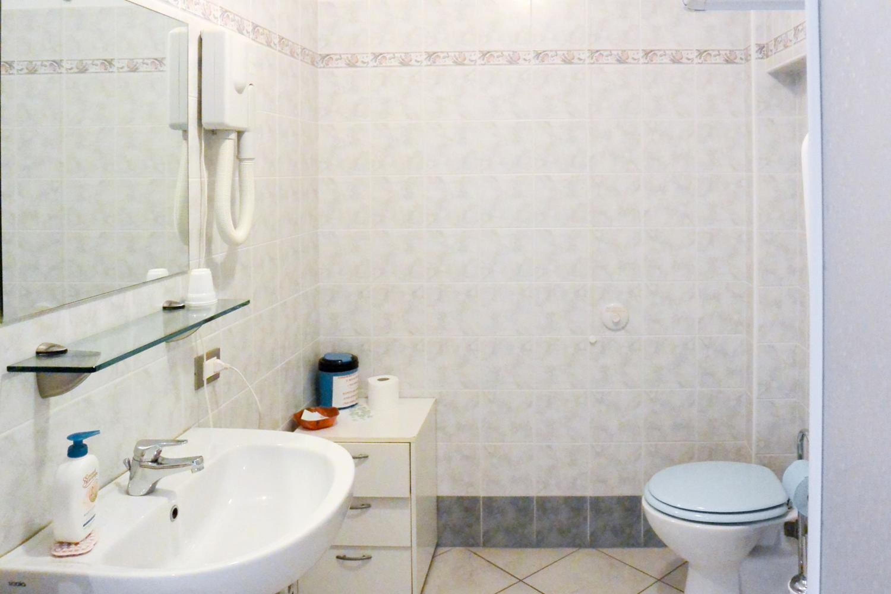 Ein Badezimmer mit Waschbecken, Spiegel und Toilette.