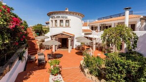 Un hotel con una edificación circular, asientos exteriores y una escalera que lleva a la entrada.