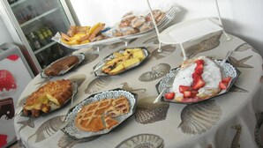 A table with various desserts and pastries, including pies and a cake with strawberries. - Del Sole (San Vincenzo)