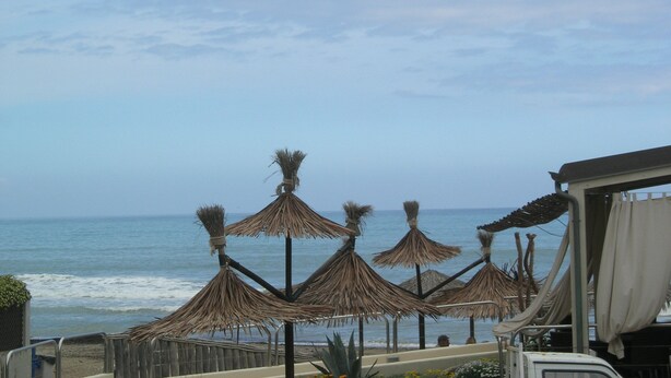 A beach view with thatched umbrellas and a view of the ocean. - Del Sole (San Vincenzo)