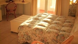 A bedroom with a bed, a chair, a desk, and a window. - Del Sole (San Vincenzo)
