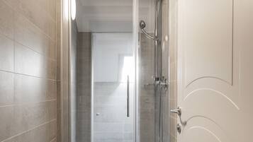 Une salle de bain moderne avec une douche à parois de verre, des toilettes et un porte-serviettes.