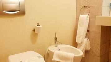 A bathroom with a toilet, bidet, and sink.