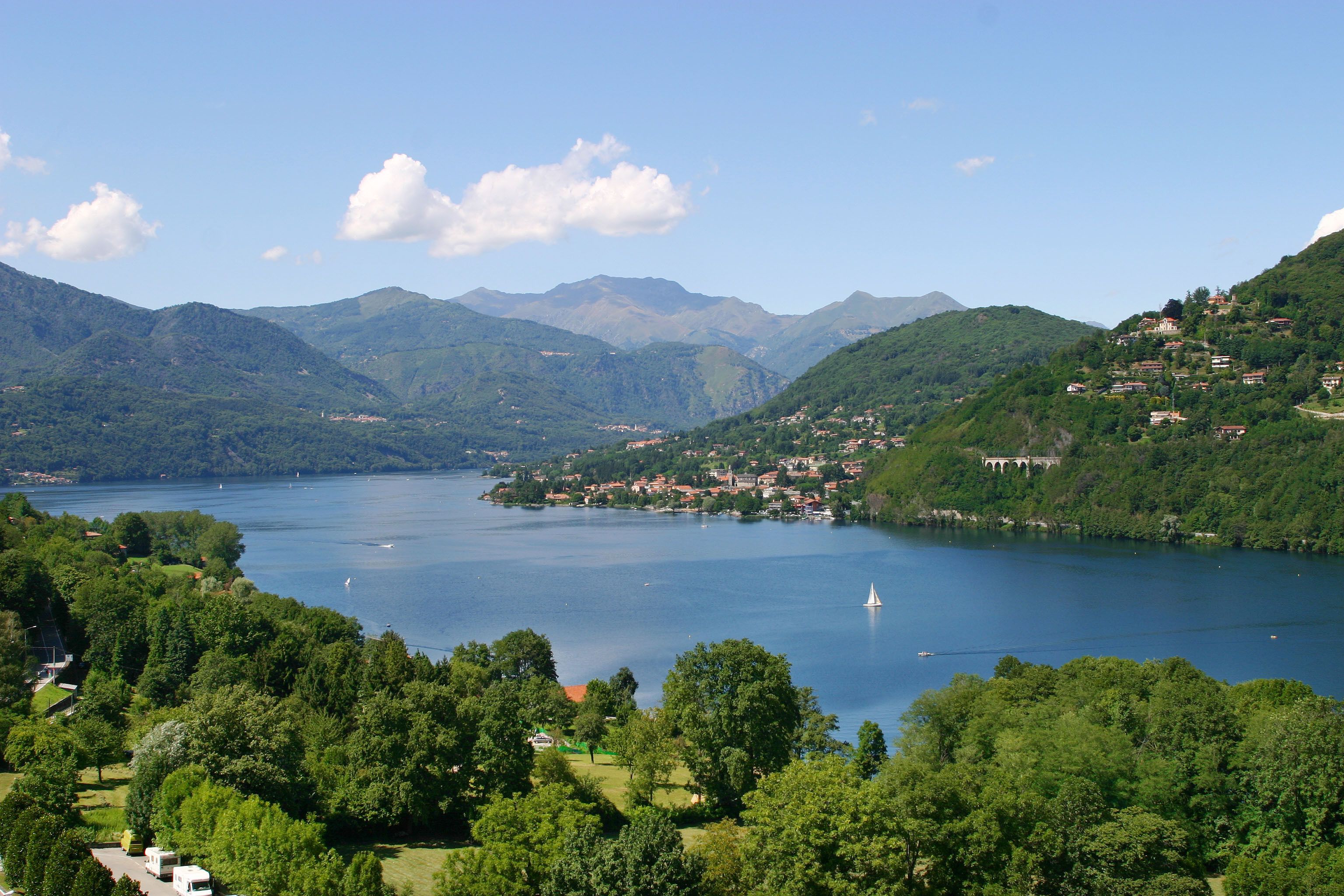 A lake surrounded by mountains and a small town with houses and buildings.