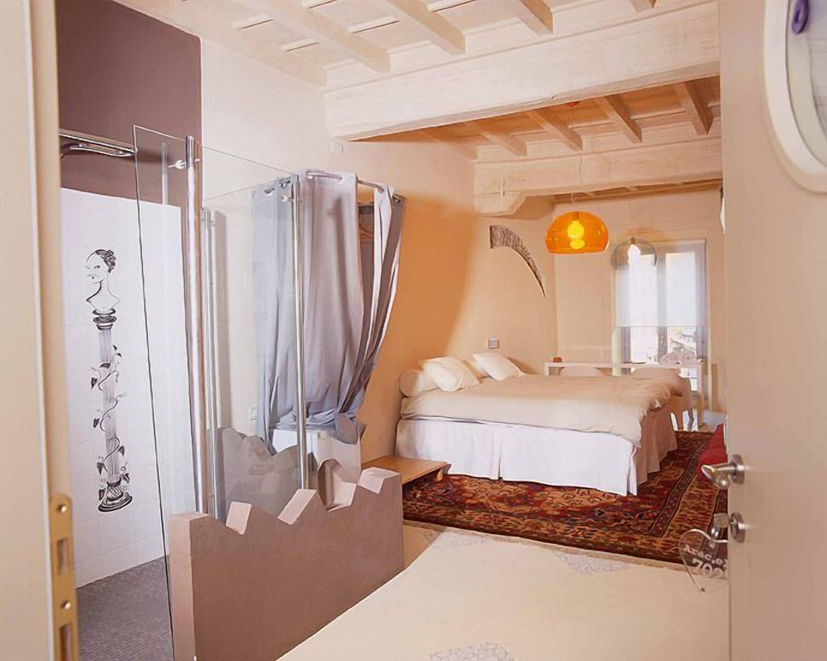 Un dormitorio con cama, ducha y baño.