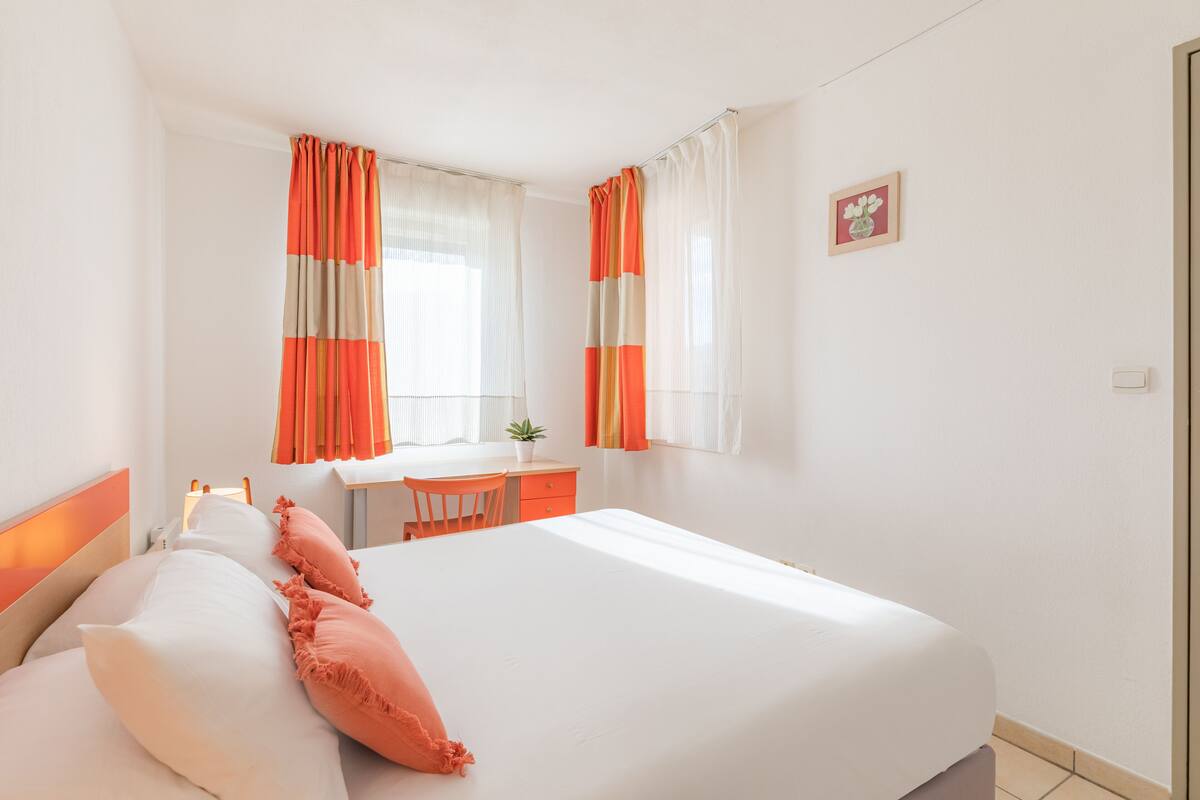 Een hotelkamer met een bed, een bureau en een stoel.
