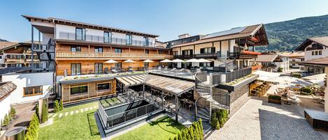 Ein modernes Hotel mit mehreren Balkonen, Außenbereichen zum Sitzen und einem Innenhof.