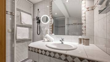 Un baño moderno con un espejo grande, un calentador integrado y un tocador con lavamanos.