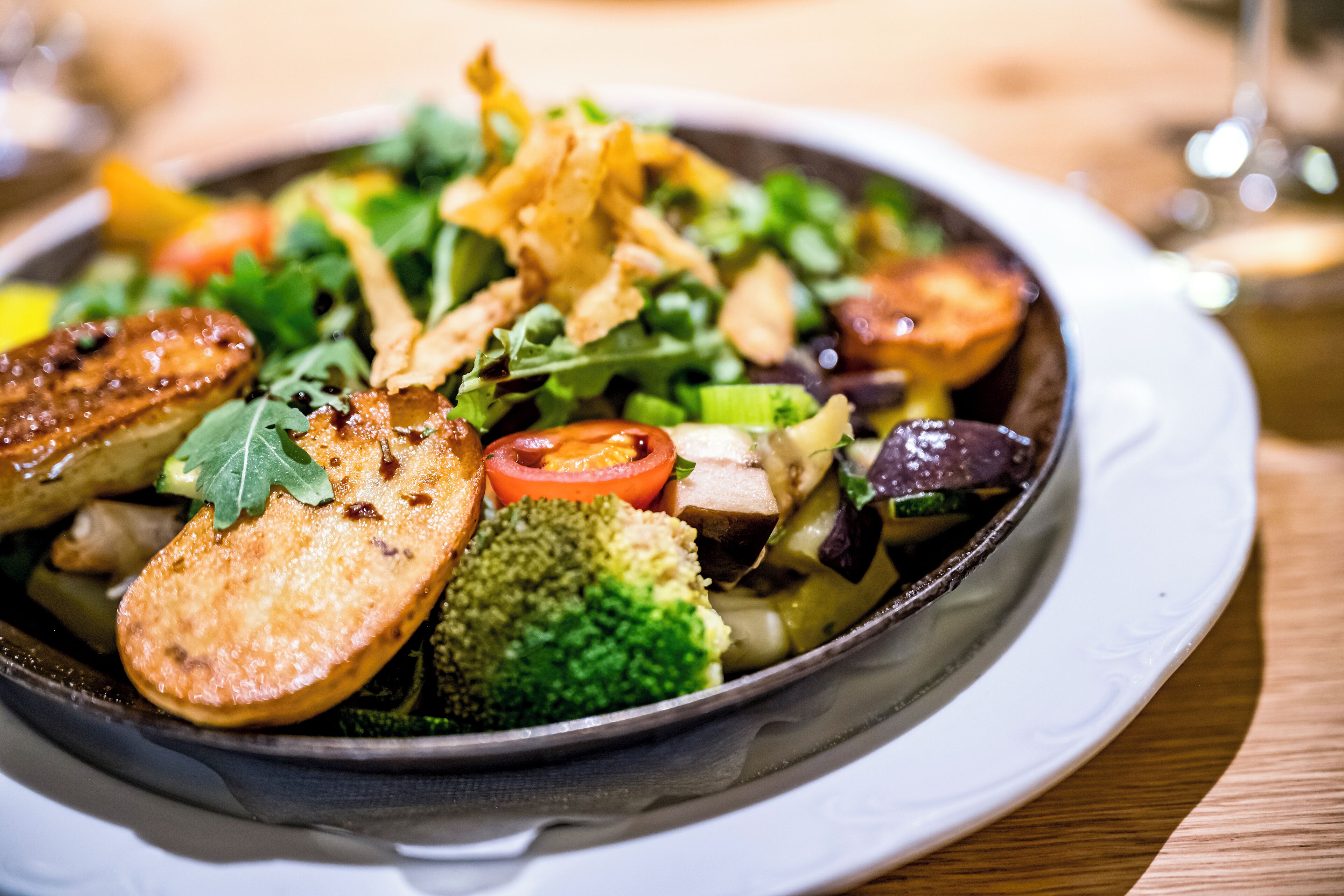 Un tazón de ensalada con diversos vegetales y carne a la parrilla.